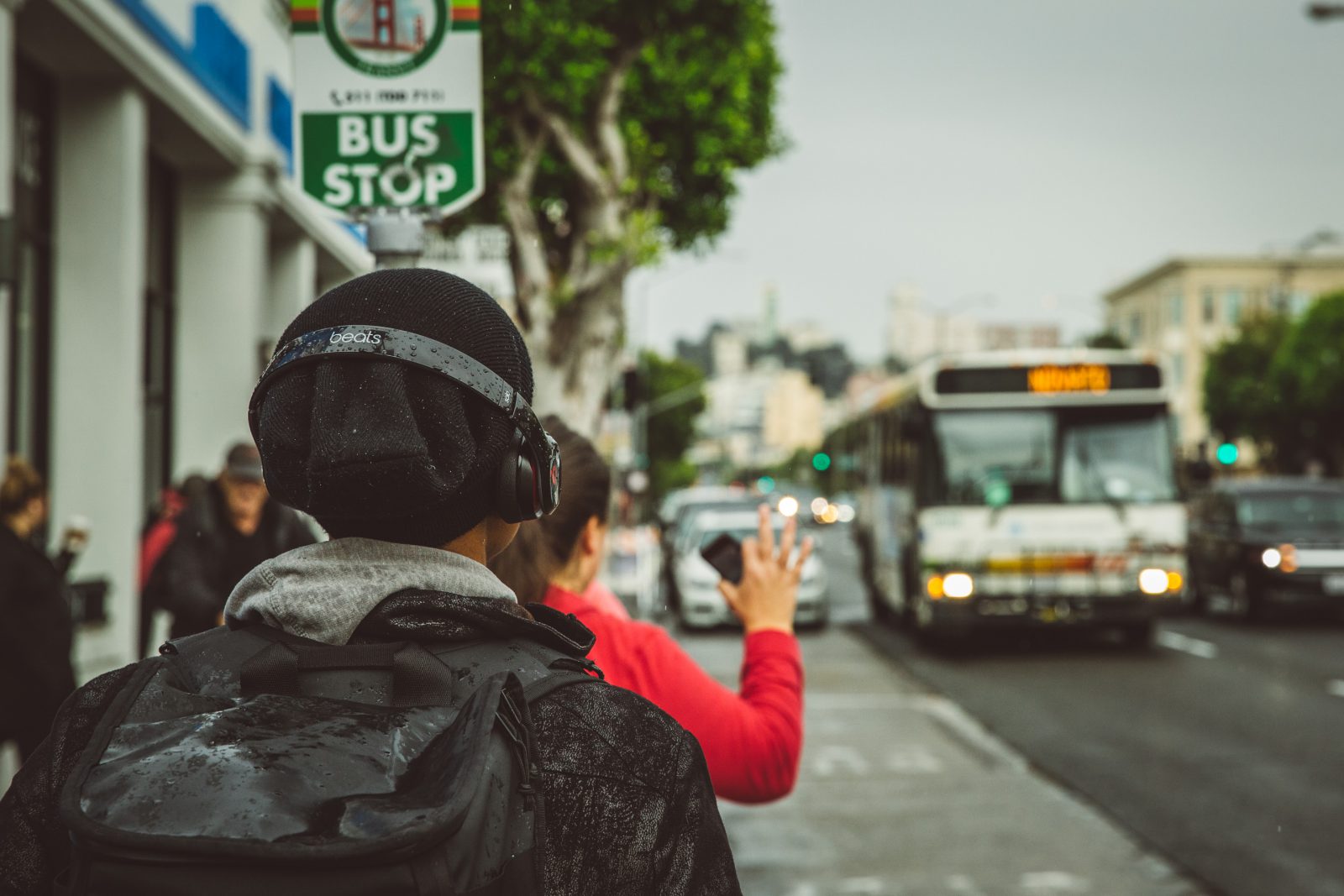 guy waiting for bus listening to music